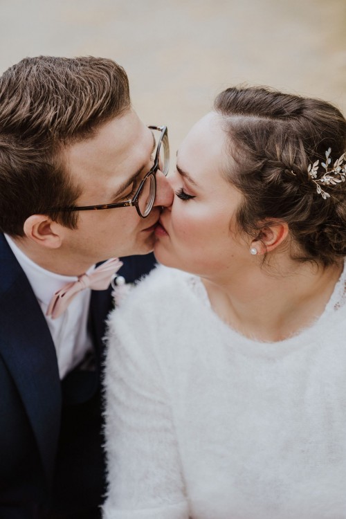 Eine Braut und ein Bräutigam küssen sich.