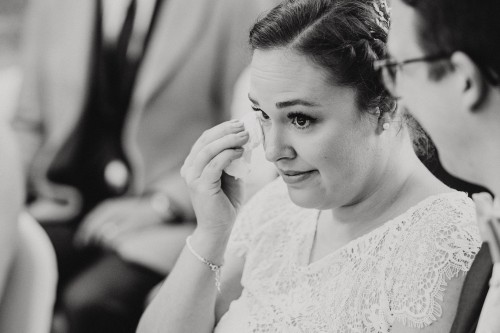 Eine Braut wischt sich eine Träne ab.