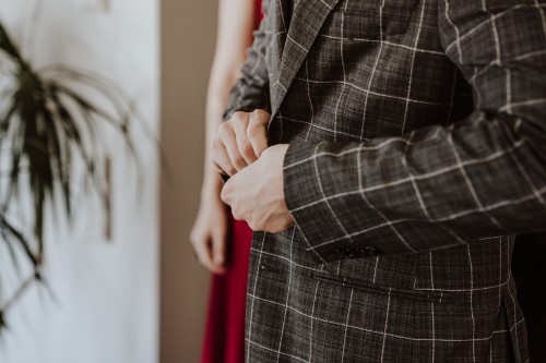 Ein Mann knöpft seinen Anzug zu.