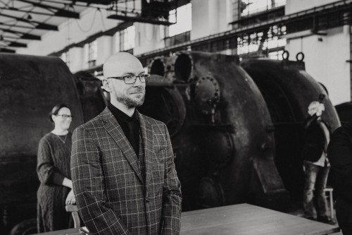 Ein schwarz-weißes Bild von einem Bräutigam in einer Maschinenhalle.