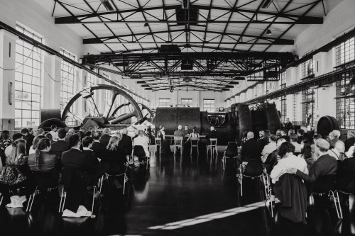 Ein schwarz-weißes Bild von einer Trauung in einer Maschinenhalle.