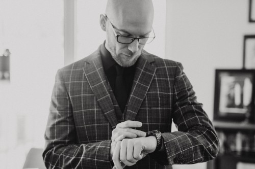 Ein Bräutigam schaut auf seine Uhr.