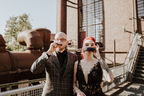 Ein Brautpaar trinkt aus einem Flachmann.