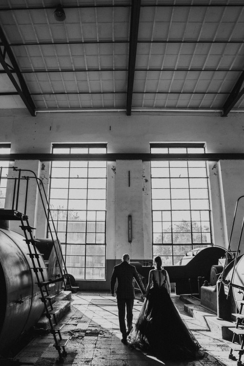 Ein Brautpaar geht durch eine Maschinenhalle.