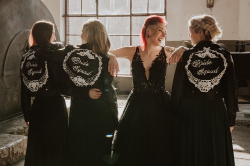 Eine Braut und ihre Brautjungfern stehen zusammen in einer Halle.