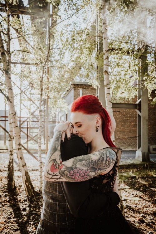 Ein Brautpaar umarmt sich zwischen den Bäumen.