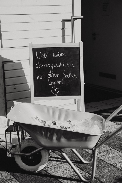 Eine Schubkarre und eine beschriftete Kreidetafel.