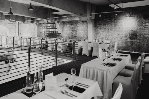 Ein Raum mit festlich gedeckten Tischen.