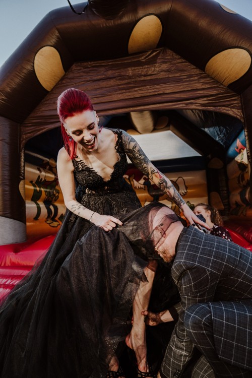 Ein Bräutigam hilft einer Braut Schuhe anzuziehen.