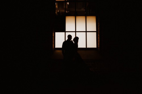 Ein Paar steht nachts vor einem Fenster.