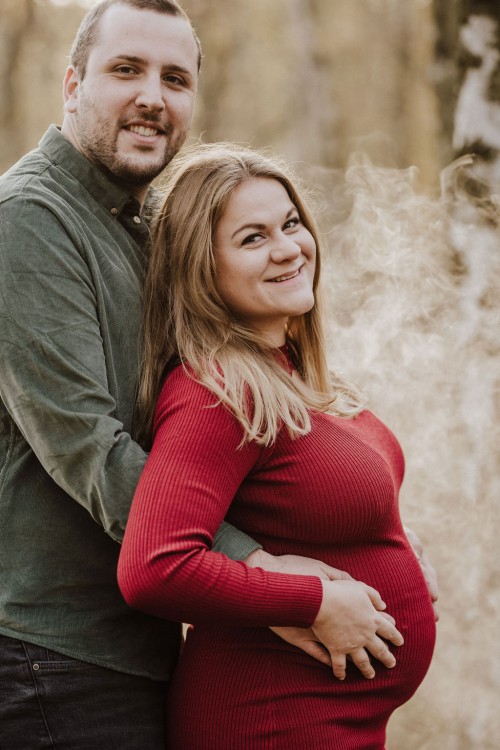 Ein Mann und eine Frau umarmen sich und schauen lächelnd in die Kamera.