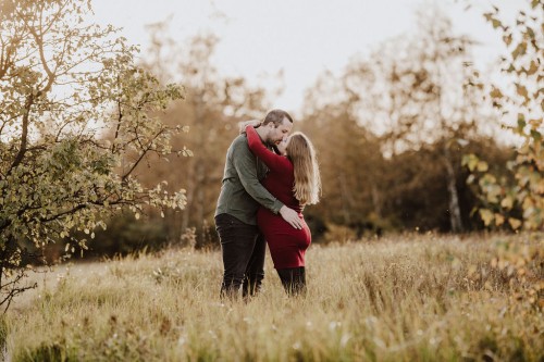 Ein Mann und eine Frau küssen sich auf einem Feld.