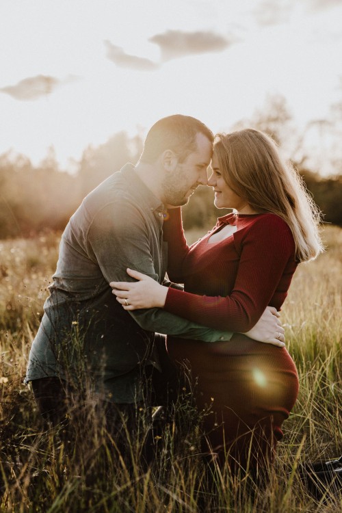 Ein Mann und eine Frau umarmen sich auf einem Feld.