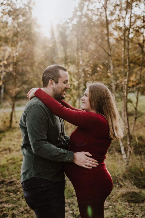 Ein Mann und eine Frau umarmen sich im Wald.