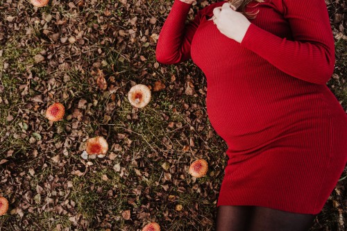 Ein Schwangerschaftsbauch im roten Kleid.