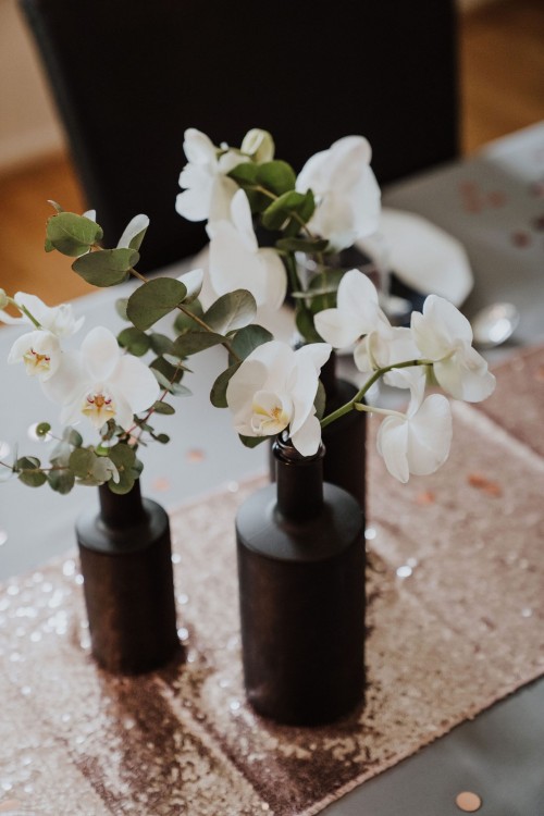 Ein Tisch mit Orchideen in den Blumenvasen.