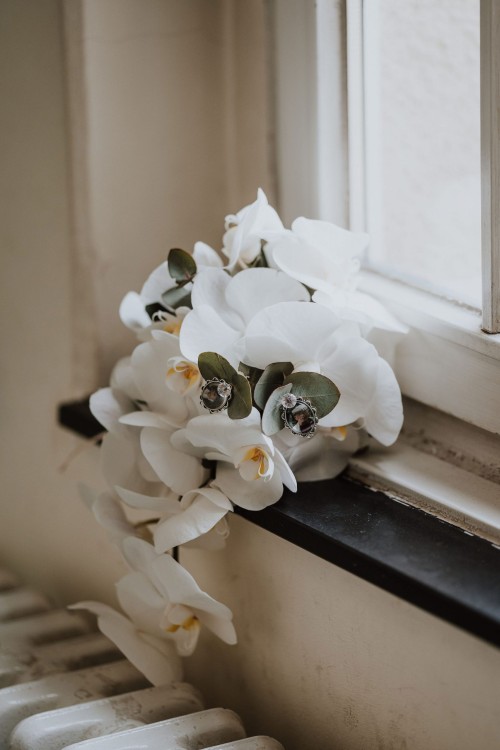 Ein Orchideenstrauß liegt auf einer Fensterbank.