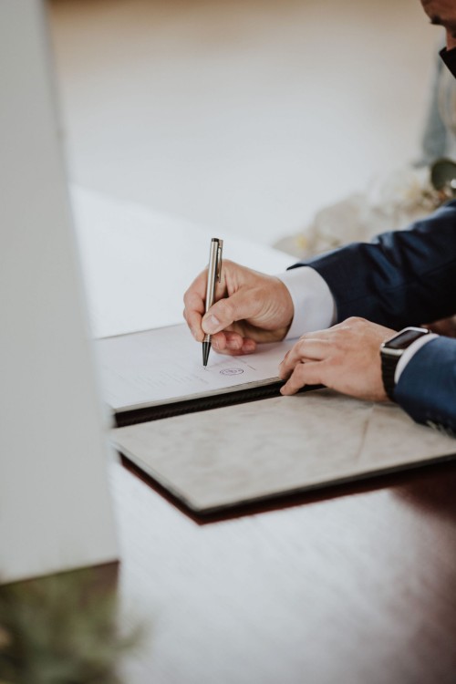 Ein Mann unterschreibt ein Dokument.