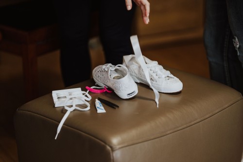 Brautschuhe und Make up Accessoires auf einem Hocker.