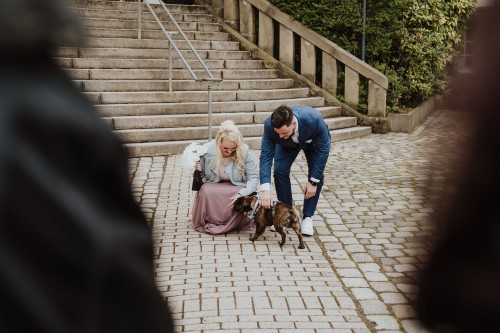 Ein Brautpaar streichelt einen Hund.