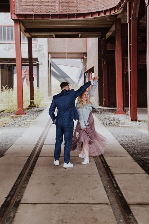 Ein Brautpaar tanzt in einer industriellen Kulisse.