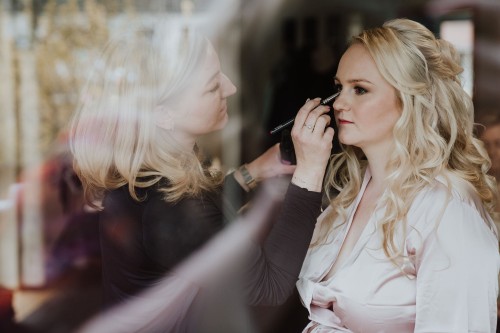 Eine Frau wird geschminkt und gestylt.