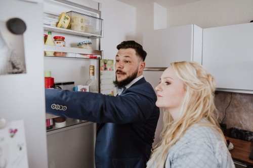 Ein Mann und eine Frau schauen in den Kühlschrank.