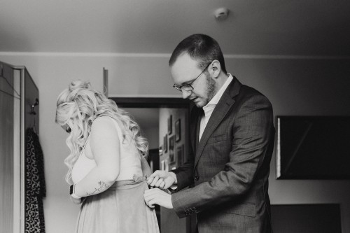 Ein Mann hilft einer Frau beim anziehen.