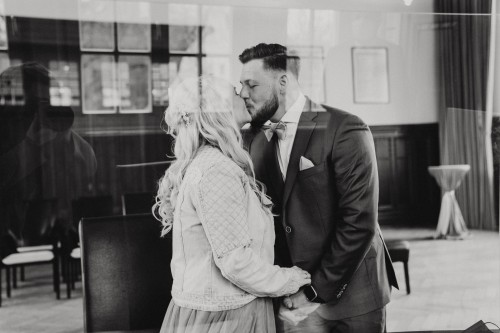 Ein schwarz-weißes Bild von einem küssenden Brautpaar.