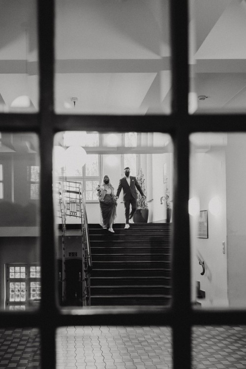 Das Brautpaar geht die Treppe runter im Standesamt.