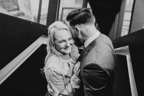 Ein schwarz-weißes Bild von einem kuschelnden Brautpaar.