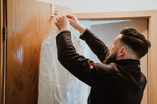 Ein Mann hängt ein Hemd auf.