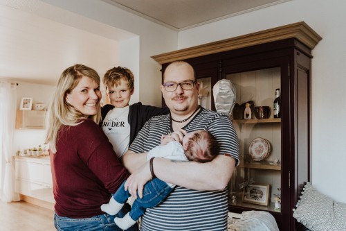 Ein Familienportrait von einer Frau, einem Mann und deren zwei Kindern.