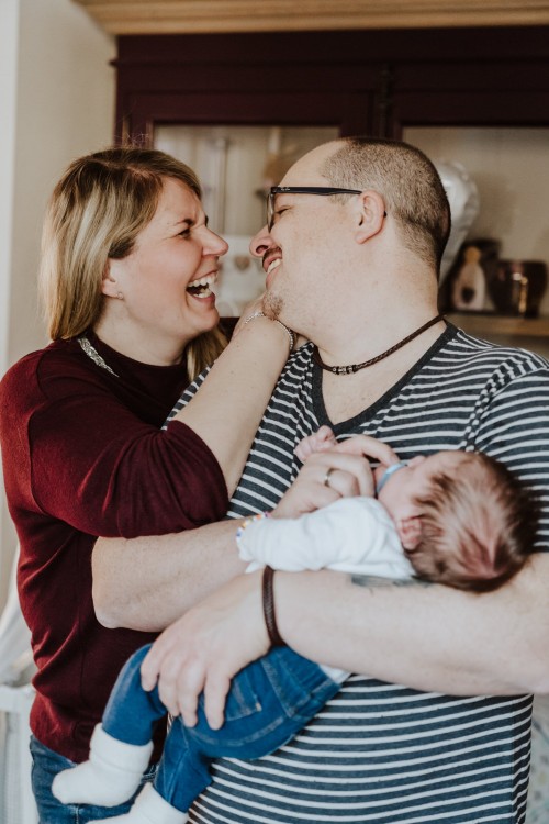 Eine Frau und ein Mann, der ein Baby im Arm helt