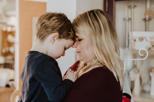 Eine Frau, die einen Jungen in ihren Armen hält.