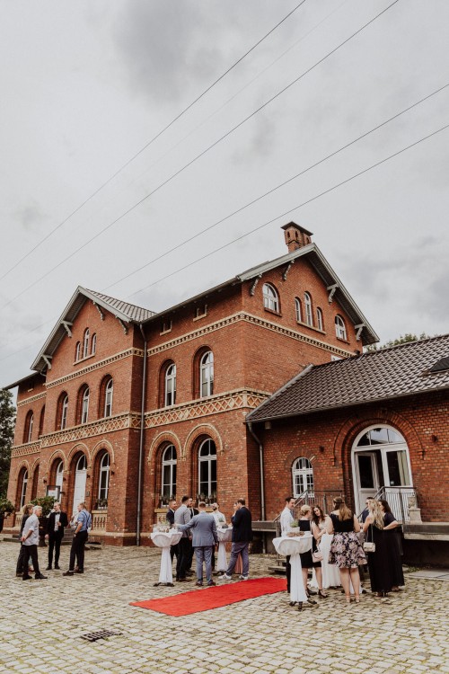 Eine Gruppe von Menschen stehen vor einem Gebäude.