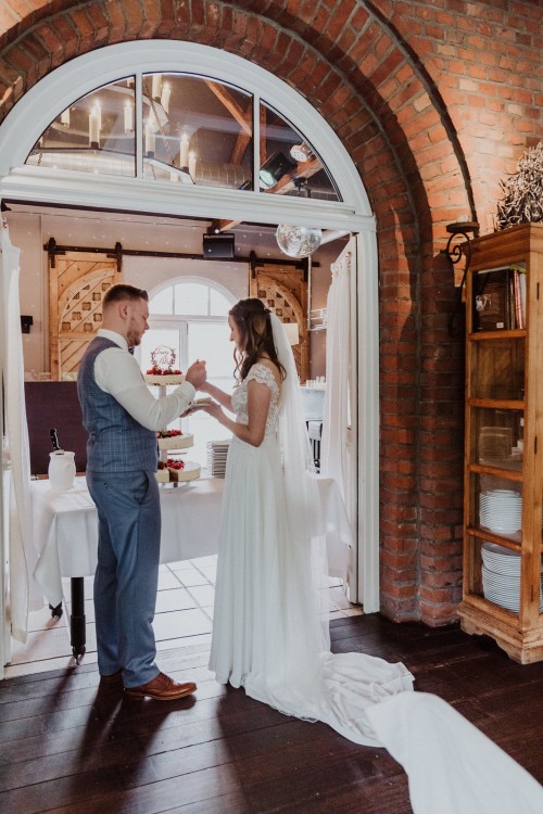 Eine Braut und ein Bräutigam füttern sich gegenseitig mit der Hochzeitstorte.