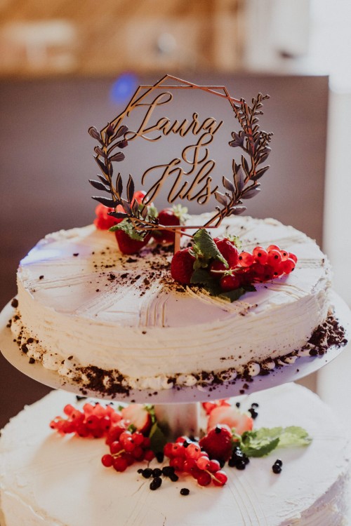 Eine Hochzeitstorte mit Beeren dekoriert.