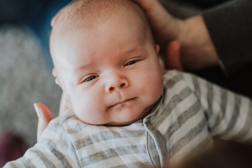 Ein kleines Baby schaut direkt in die Kamera.