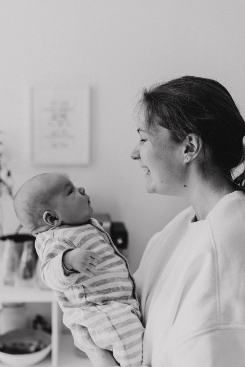 Eine Frau schaut ein kleines Baby liebevoll an.