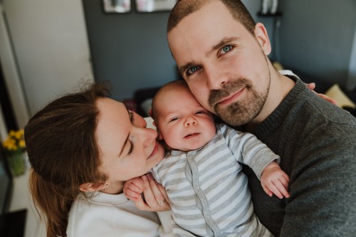 Eine Frau und ein Mann halten ein Baby hoch.