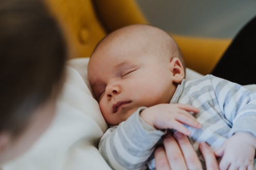 Eine Frau hält ein schlafendes Baby im Arm.