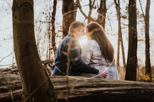 Ein Mann und ein Frau sitzen auf einem umgefallenem Baumstamm.