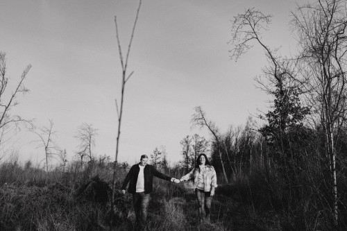 Ein Mann und ein Frau gehen einen Feldweg und halten dabei Händchen.