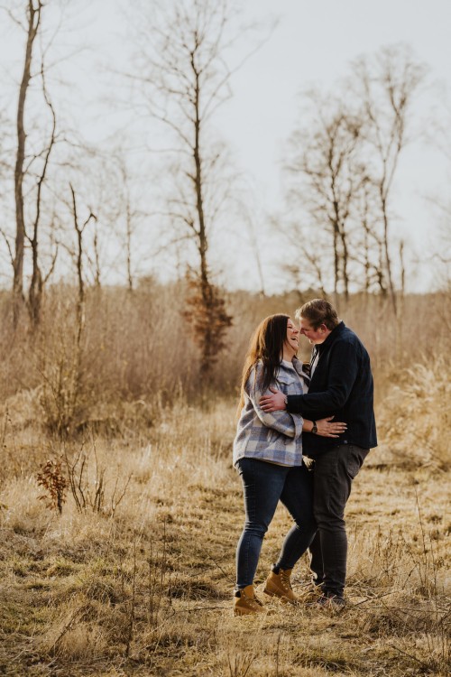 Eine Frau und ein Mann umarmen sich auf einer Wiese.