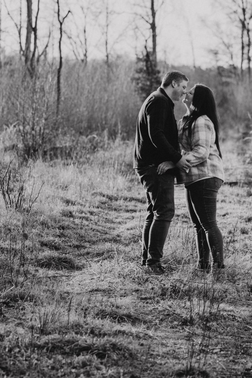 Ein Mann und ein Frau knutschen auf einer Wiese.