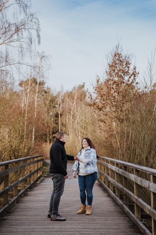 Ein Mann und eine Frau stehen auf einer Holzbrücke.