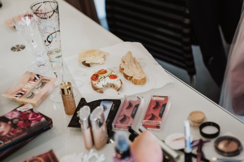 Ein Tisch mit Kosmetik und Schnittchen drauf.
