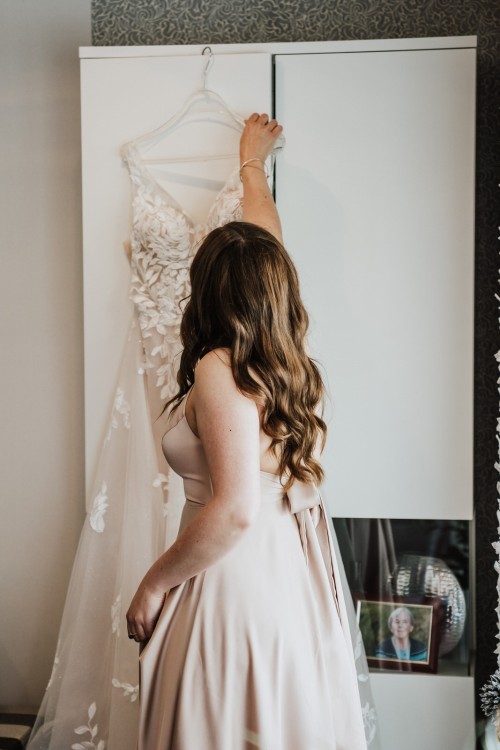 Eine Frau greift zu ihren Brautkleid .