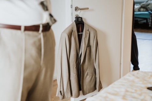 Ein Sakko hängt auf einer Türklinke.